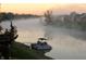 View of boat and misty lake and neighborhood homes, creating a tranquil waterside setting at 2829 Somerset Bay, Indianapolis, IN 46240