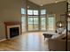 Bright living room features fireplace, light wood floors and expansive windows overlooking serene lake view at 2829 Somerset Bay, Indianapolis, IN 46240