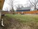 Large, grassy backyard with wood privacy fence, play-set, and mature trees at 2867 S Oakland Dr, Shelbyville, IN 46176