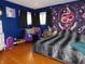 Unique bedroom with hardwood floors, bright blue walls, dark curtains and eclectic decor at 2867 S Oakland Dr, Shelbyville, IN 46176