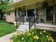 Inviting front porch with black railings, potted plants, and flowers adds curb appeal at 2867 S Oakland Dr, Shelbyville, IN 46176