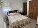 Bedroom with a floral bedspread, a dark wooden headboard and a window with floral curtains at 2927 E 8Th St, Anderson, IN 46012