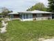 One-story home featuring a sunroom add-on, brick exterior, and green lawn at 2927 E 8Th St, Anderson, IN 46012