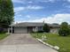 Inviting one-story home featuring a spacious driveway and landscaped front yard at 2927 E 8Th St, Anderson, IN 46012
