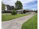 Attractive one-story home with a concrete driveway, manicured lawn, and mature trees at 2927 E 8Th St, Anderson, IN 46012