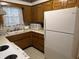Functional kitchen with wood cabinets, laminate countertops, and a white refrigerator at 2927 E 8Th St, Anderson, IN 46012