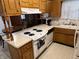 Cozy kitchen featuring white appliances, plenty of counter space, and wood cabinetry at 2927 E 8Th St, Anderson, IN 46012