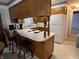 Eat-in kitchen featuring a breakfast bar, wood cabinetry, and white appliances at 2927 E 8Th St, Anderson, IN 46012