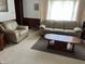 Comfortable living room features a plush sofa, armchair and a wood coffee table on a brown area rug at 2927 E 8Th St, Anderson, IN 46012