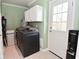 Functional laundry room with modern washer and dryer, storage cabinets, and exterior access at 296 W Greencastle Rd, Mooresville, IN 46158