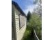 View of side exterior, showing boarded window, yard and siding at 3242 Collier St, Indianapolis, IN 46221