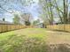Large backyard with green grass, new wooden fence, and a shed in the background at 3411 Chase St, Indianapolis, IN 46217