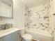 Modern bathroom with marble-patterned tile in the tub, updated fixtures and a stylish vanity with ample storage space at 3411 Chase St, Indianapolis, IN 46217