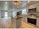 Open kitchen with island, stainless steel appliances, modern cabinets, and great natural light into the living room at 3411 Chase St, Indianapolis, IN 46217