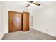 Bedroom with carpeted floor, ceiling fan and wood paneled closet with a door leading to another room at 374 S Baldwin St, Bargersville, IN 46106