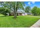 Brick home nestled on a green lot with mature trees, featuring an attached garage and a paved driveway at 374 S Baldwin St, Bargersville, IN 46106