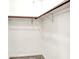Empty walk-in closet with carpeted floor, white walls, and brown wood shelf supports at 374 S Baldwin St, Bargersville, IN 46106