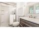 Modern bathroom with glass shower door, neutral-toned vanity, toilet, and window at 411 Woodland W Dr, Greenfield, IN 46140