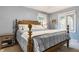Cozy bedroom featuring soft blue walls, a wooden bed frame, and windows providing natural light at 411 Woodland W Dr, Greenfield, IN 46140