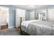 A bright bedroom with a white dresser, a doorway to the bathroom, and a mirrored closet door at 411 Woodland W Dr, Greenfield, IN 46140