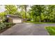 Spacious driveway leading to the garage, surrounded by mature trees and landscaping at 411 Woodland W Dr, Greenfield, IN 46140