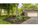 Gravel driveway with mature trees and landscaped mulch bed at 411 Woodland W Dr, Greenfield, IN 46140