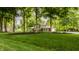 Beautiful home with lush green lawn, mature trees, and attached garage at 411 Woodland W Dr, Greenfield, IN 46140