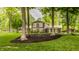 Well-maintained home featuring manicured lawn, mulch beds, and mature trees at 411 Woodland W Dr, Greenfield, IN 46140