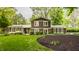 Charming home with brick accents, lush landscaping, and a well-kept lawn at 411 Woodland W Dr, Greenfield, IN 46140