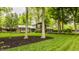 Inviting home surrounded by a lush lawn, mature trees, and landscaped flower beds at 411 Woodland W Dr, Greenfield, IN 46140