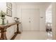 Inviting foyer with decorative table, neutral tile flooring, and double doors at 411 Woodland W Dr, Greenfield, IN 46140