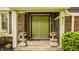 Welcoming front porch with double doors, potted plants, and brick accents at 411 Woodland W Dr, Greenfield, IN 46140