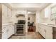 Bright kitchen features white cabinets, modern stainless steel appliances, and adjacent dining area at 411 Woodland W Dr, Greenfield, IN 46140