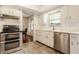 Well-lit kitchen showcases stainless steel appliances, white cabinets, and view into the dining room at 411 Woodland W Dr, Greenfield, IN 46140