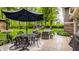 Relaxing backyard patio with comfortable seating, an umbrella, and surrounding greenery at 411 Woodland W Dr, Greenfield, IN 46140