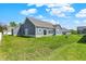 Expansive backyard view highlights the exterior facade, sliding glass door, and lush lawn at 49 Manchester Dr, Trafalgar, IN 46181