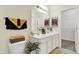 Well-lit bathroom featuring double sinks, decorative art, and an adjacent walk-in closet at 49 Manchester Dr, Trafalgar, IN 46181