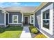 Inviting home entrance with gray siding, a decorated front door, and landscaped greenery at 49 Manchester Dr, Trafalgar, IN 46181