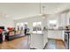 Open concept kitchen and living area with an island, hardwood floors, and lots of natural light at 49 Manchester Dr, Trafalgar, IN 46181