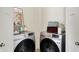 Modern laundry room with stainless steel Samsung washer and dryer and decorative storage options at 49 Manchester Dr, Trafalgar, IN 46181