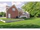 Expansive backyard with lush lawn and a brick home featuring a white deck and a bright sunroom at 4956 Waterside Cir, Carmel, IN 46033
