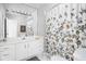 Bright bathroom with a floral shower curtain, white vanity, and tile flooring at 4956 Waterside Cir, Carmel, IN 46033