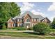 Stunning two-story brick home featuring a symmetrical design, well-manicured lawn, and mature trees at 4956 Waterside Cir, Carmel, IN 46033