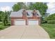 Two-car garage with white doors and brick exterior, adding convenience and curb appeal to the home at 4956 Waterside Cir, Carmel, IN 46033