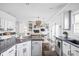 Bright, open kitchen with an island, white cabinets, and views into the living area at 4956 Waterside Cir, Carmel, IN 46033