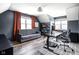 Well-lit home office with a gray sofa, floating shelves, and an adjustable desk at 4956 Waterside Cir, Carmel, IN 46033