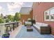 Outdoor patio with wicker furniture, blue rug, and a brick exterior wall, perfect for relaxing and entertaining at 4956 Waterside Cir, Carmel, IN 46033