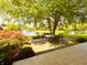 Serene backyard patio with outdoor dining set, overlooking a picturesque pond with fountains and lush landscaping at 5190 Pursel Ln, Carmel, IN 46033