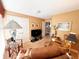 Cozy living room with tan walls and carpet featuring comfortable furniture and natural light from the window at 5190 Pursel Ln, Carmel, IN 46033