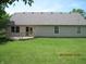 View of the home's back exterior with a wood deck, neutral siding and a manicured lawn at 533 Charnwood Pkwy, Beech Grove, IN 46107